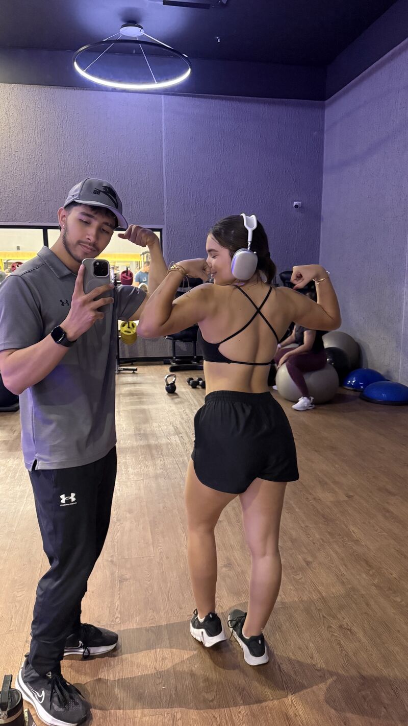 Yair y una clienta mostrando sus resultados en el gimnasio