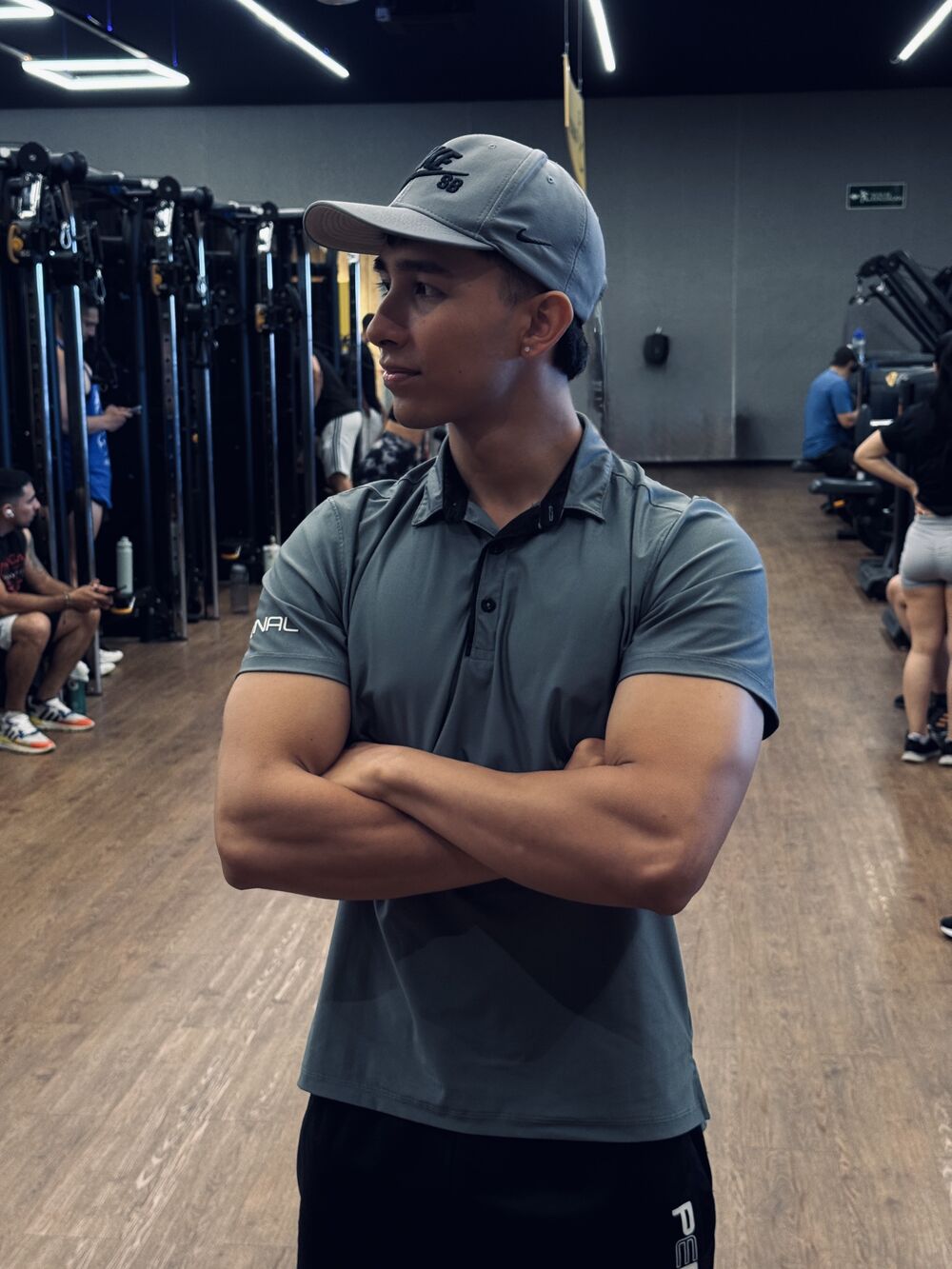 Yair, entrenador personal, de brazos cruzados en el gimnasio
